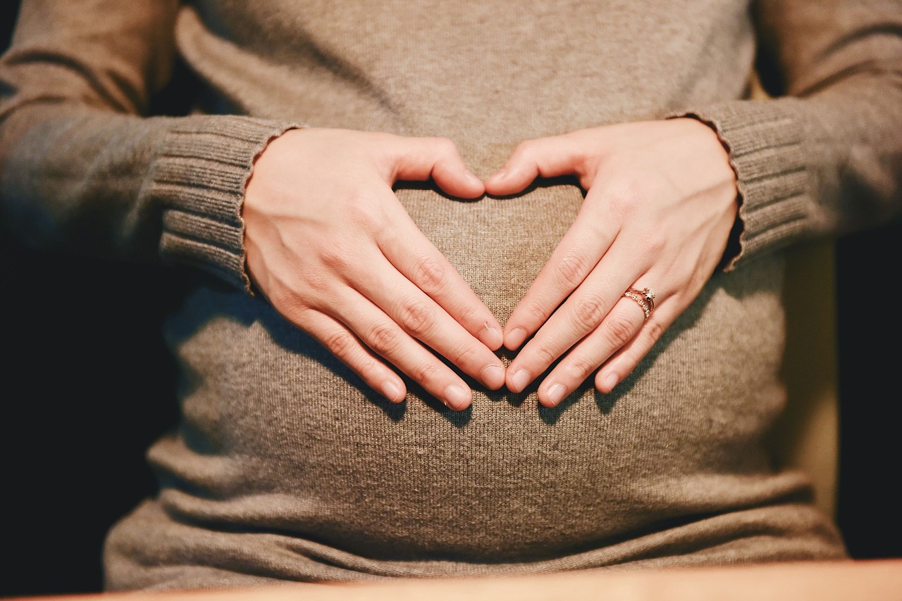 Hands on Pregnant belly in the shape of a heart